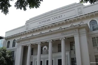The photo shows the facade of the Supreme Court in Manila.